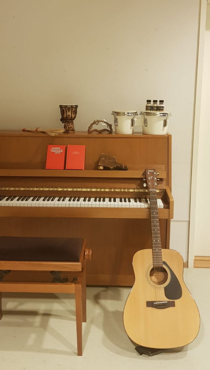 kuvassa, piano, kitara, rytmisoittimia ja Nuoren seurakunnan veisukirjoja