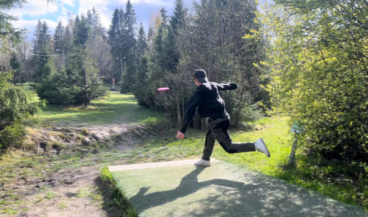 Frisbeegolfkerho frisbeegolfrata, nuori mies heittämässä kiekkoa